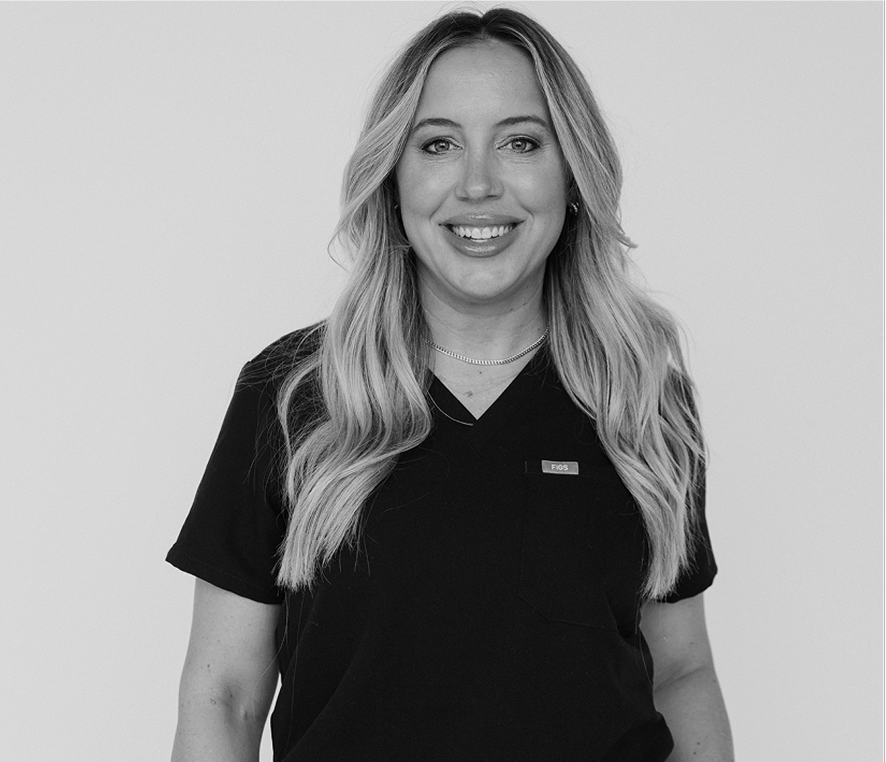 Smiling woman with long blonde hair wearing a black shirt.